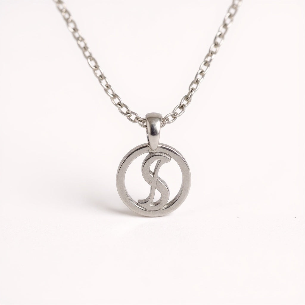 Close-up of hand-stamped astrological zodiac symbol on polished silver pendant